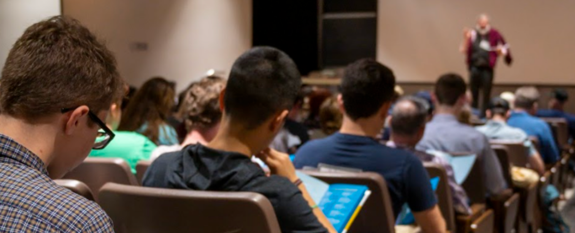 photo from behind group of students in lecture hall