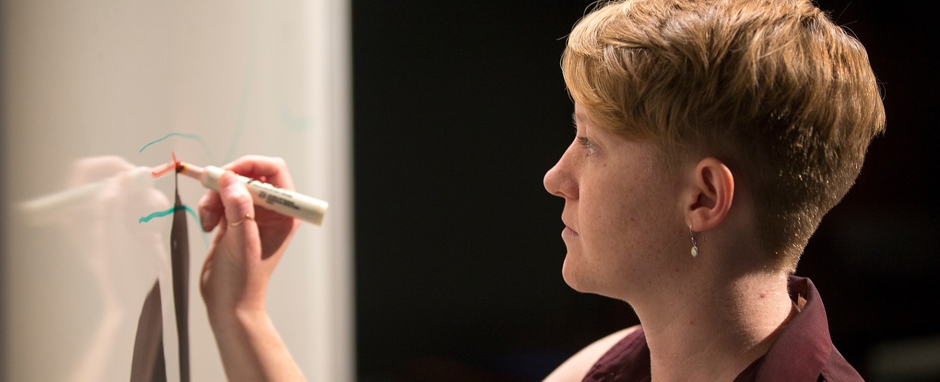 photo of person writing on a whiteboard