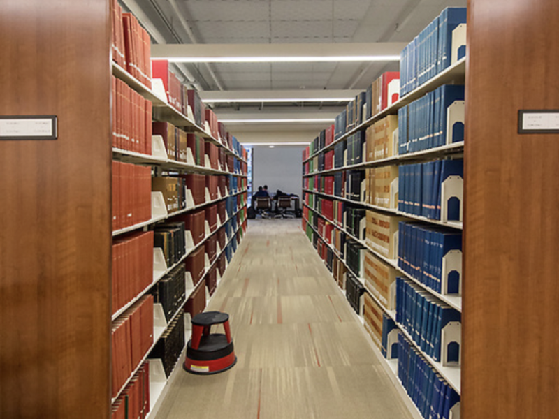 photo looking down a row of bookshelves in a library